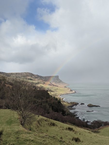 Murlough Bay - a location used by Game of Thrones on several occasions - and for good reason given the variety its steep cliffs, rolling landscapes and beautiful bay deliver. Throw in the odd rainbow, and a view through to Rathlin Island, as in this photo and you've got a memory of your responsible hiking in Northern Ireland that you will never forget