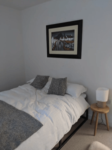 Woollen cushions and throws hand-woven in Northern Ireland by Mourne Textiles, along with the painting by local artist Rooney, provide the focal points in the muted but stylish guest double bedroom on the ground floor