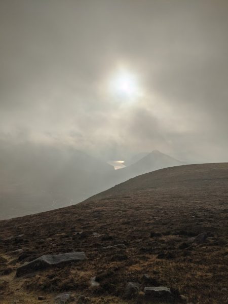 The low winter sun forcing its way through the clouds to light up the Silent Valley reservoir and silhouette Doan, to give a spectacular view from half way up Meelmore in the Mournes